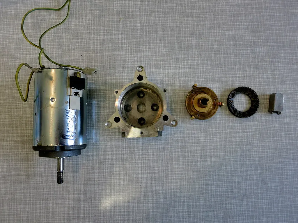 Ein zerlegtes Mahlwerk mit Motor, Gehäuse und Mahlscheiben nebeneinander
