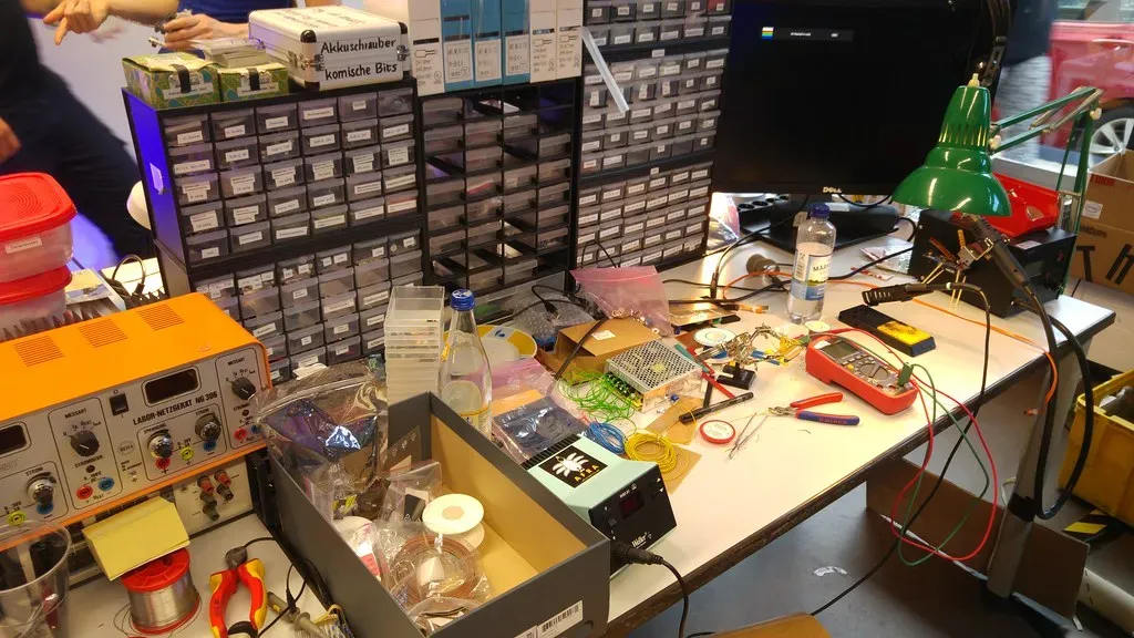 Werkbank mit Lötstation, Messgerät und sortierten Kleinteilen
